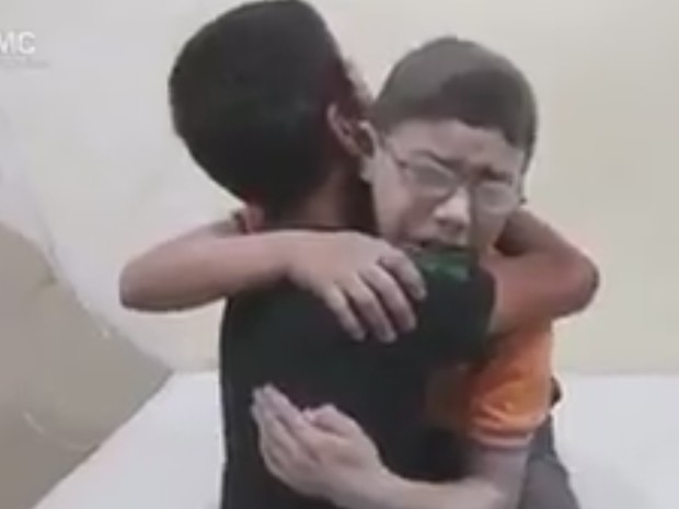 Meninos se abraçam após saber da morte de irmão em ataque em Aleppo, no norte da Síria (Foto: AMC/ Reprodução G1) Meninos se abraçam após saber da morte de irmão em ataque em Aleppo, no norte da Síria (Foto: AMC/ Reprodução G1)