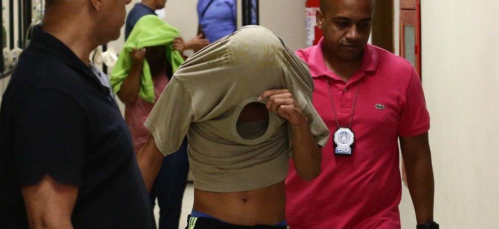 Um dos suspeitos de participar do estupro coletivo de uma menina de 12 anos na Baixada Fluminense chega à Delegacia da Criança e do Adolescente Vítima (Dcav), na Lapa, centro do Rio de Janeiro (Foto: FÁBIO MOTTA/ESTADÃO CONTEÚDO)