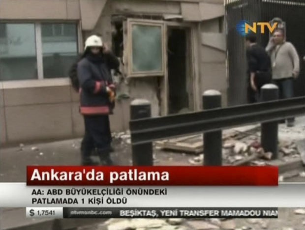 Imagem da TV local mostra policial no local da explosão em frente ao prédio da Embaixada dos EUA em Ancara, na Turquia, nesta sexta-feira (1º) (Foto: AP)