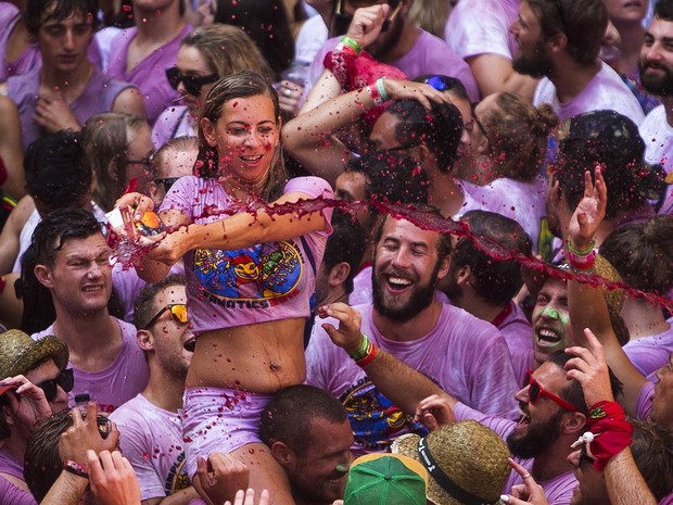 Mulher participa de guerra de vinho durante o Chupinazo, abertura do Festival de São Firmino em Pamplona, na Espanha (Foto: Andres Kudacki/AP)