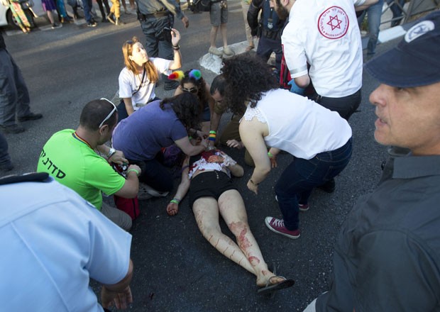 Paramédicos atendem pessoa atacada com faca durante a Parada Gay de Jerusalém nesta quinta-feira (30) (Foto: Sebastian Scheiner/AP)