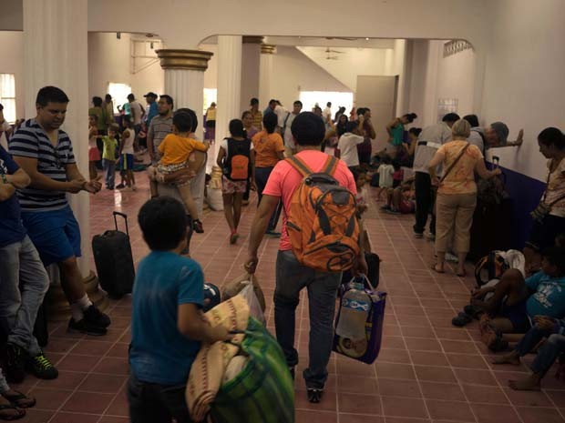 Famílias chegam a albergue habilitado para esperar a chegada do furacão Patricia em Puerto Vallarta, no México (Foto: AP Photo/Cesar Rodriguez)