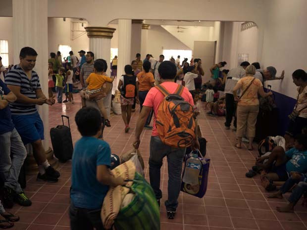 Famílias chegam a albergue habilitado para esperar a chegada do furacão Patricia em Puerto Vallarta, no México (Foto: AP Photo/Cesar Rodriguez)