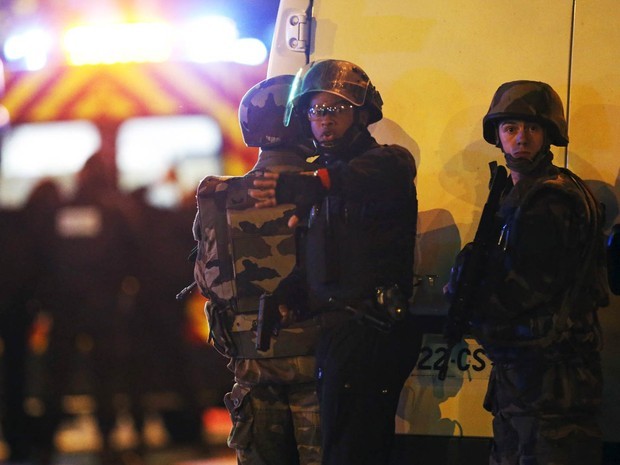 Policial pede para pessoas se afastarem de área isolada perto do Bataclan, alvo de ataque terrorista em Paris