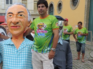 Volnei Mendes ao lado da figura do pai, que foi músico da banda Amor e Arte (Foto: Mariana de Ávila/G1)