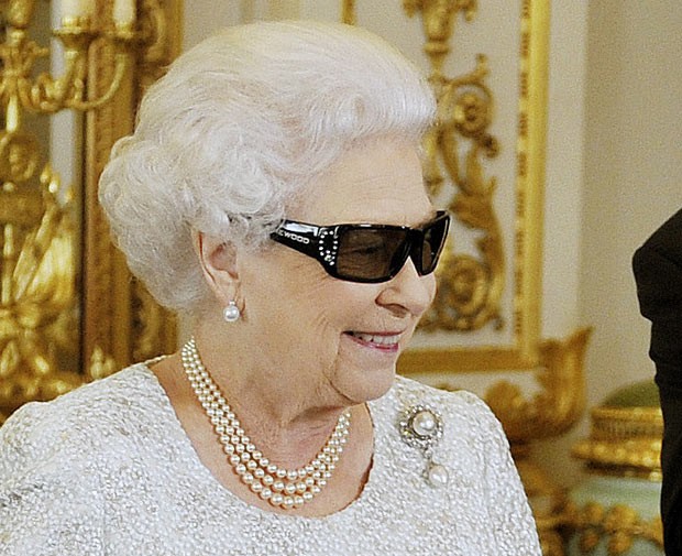 A Rainha Elizabeth II usa óculos 3D em 7 de dezembro em Buckimgham (Foto: AP)