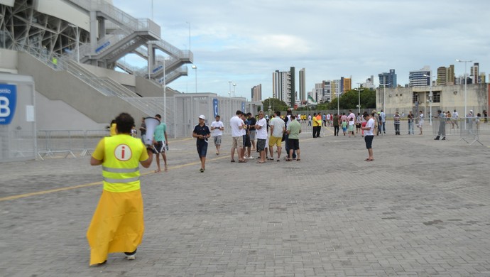 Voluntário informa aos torcedores os portões de acesso na Arena das Dunas (Foto: Jocaff Souza)