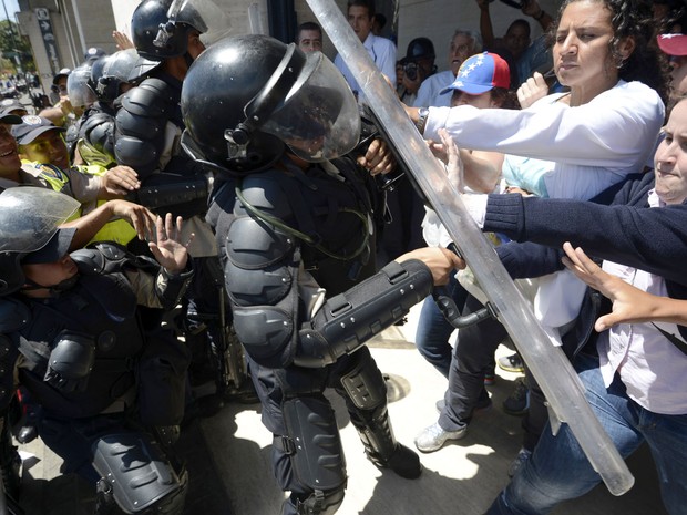 Trabalhadores da saúde pública venezuelana brigam com a polícia de choque durante um protesto em Caracas. (Foto: Juan Barreto/AFP)