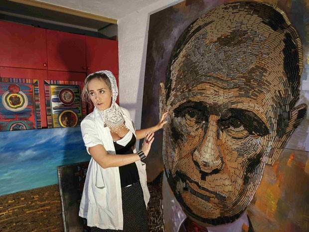 A artista ucraniana Dariya Marchenko mostra o retrato de Vladmir Putin feito com 5 mil balas; a obra se chama 'O rosto da guerra' (Foto: Gleb Garanich/Reuters) A artista ucraniana Dariya Marchenko mostra o retrato de Vladmir Putin feito com 5 mil balas; a obra se chama 'O rosto da guerra' (Foto: Gleb Garanich/Reuters)
