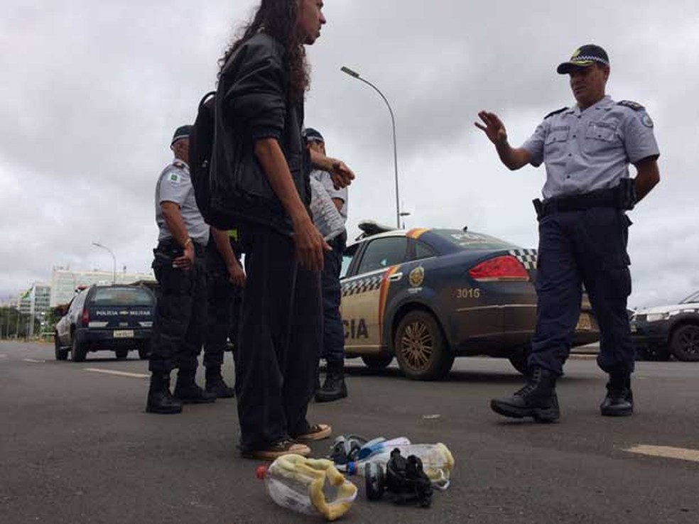 Policiais militares revistam jovem e impedem que ele ultrapasse barreira na Esplanada dos Ministérios nesta terça (13) levando máscara (Foto: Wellington Hanna/G1)