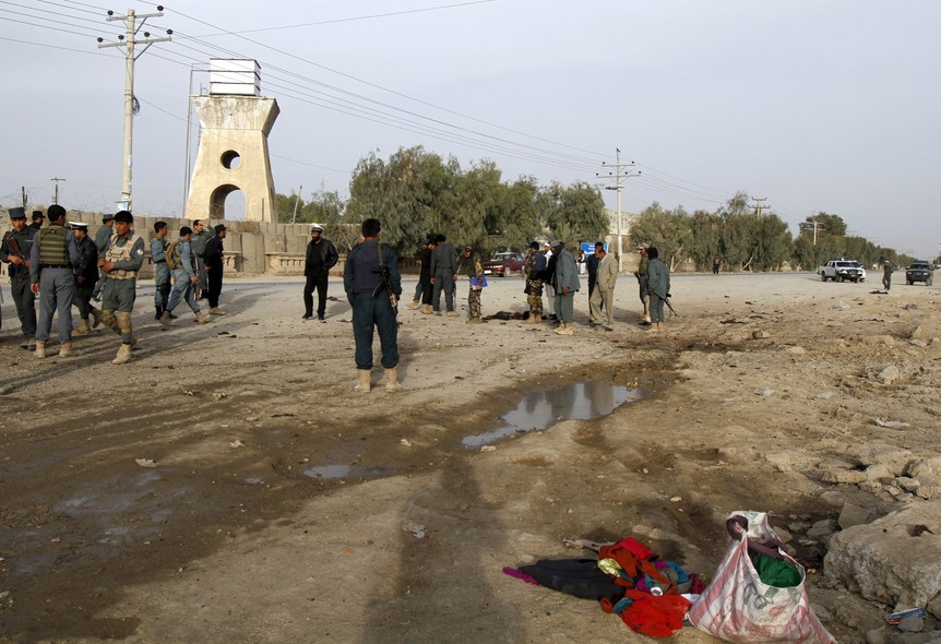 Afghan security forces inspect the site of a suicide attack in Kandahar, Afghanistan, Wednesday, Feb. 18, 2015. In southern Kandahar province, a suicide bomber struck near a police station on Wednesday, killing an Afghan woman and a small child, according