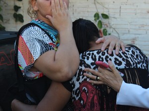 Mãe da garota é amparada por colegas na porta do hospital (Foto: Ellyo Teixeira/G1)