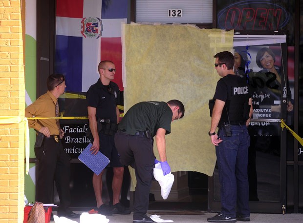 Policiais em frente ao salão em que ocorreu o crime nesta quinta-feira (18) em Casselberry, na Flórida (Foto: AP)