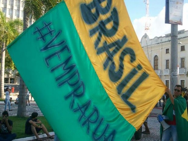 Manifestante pinta faixa para convidar outras pessoas a participarem da passeata (Foto: Flávio Antunes/G1)
