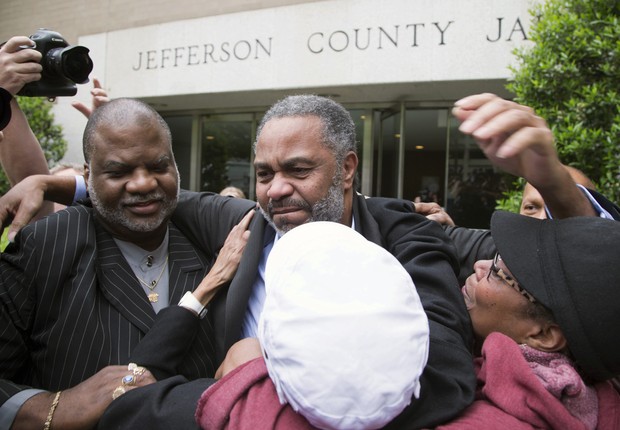 Anthony Ray Hinton (ao centro) abraça amigos e familiares ao deixar a prisão no Alabama. Ele ficou mais da metade da vida no corredor da morte (Foto: Hal Yeager/AP)