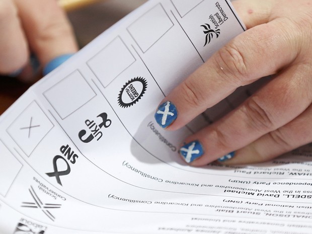 Com a bandeira escocesa pintada nas unhas, funcionária conta votos em um centro em Aberdeen, na Escócia, na quinta (7) (Foto: Reuters/Cathal McNaughton)