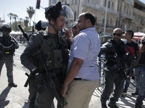 Policial israelense discute com palestino que protestava contra marcha (Foto: Ahmad Gharabli/AFP) Policial israelense discute com palestino que protestava contra marcha (Foto: Ahmad Gharabli/AFP)