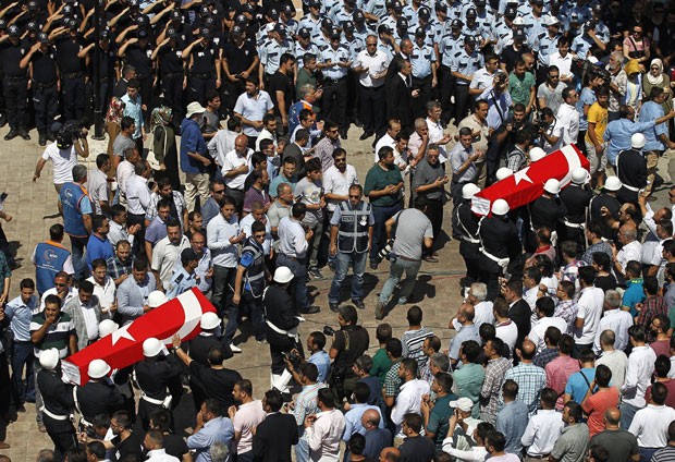 Dezenas de pessoas participam nesta quinta-feira (23) do funeral de policiais turcos que foram mortos (Foto: Emrah Gurel/AP)