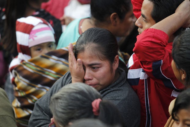 Mulher chora próximo á cena da chacina neste domingo (8) na Guatemala (Foto: Reuters)
