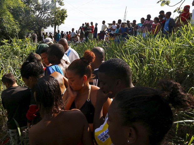 Moradores do complexo de favelas de São Carlos reagem ao verem os corpos de dois homens achados no mato, no Rio de Janeiro (Foto: Ricardo Moraes/Reuters) Moradores do complexo de favelas de São Carlos reagem ao verem os corpos de dois homens achados no mato, no Rio de Janeiro (Foto: Ricardo Moraes/Reuters)
