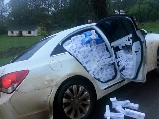 Carro só possuia o banco do motorista, o resto ficou coberto com pacotes de cigarro. (Foto: PRF/Divulgação)