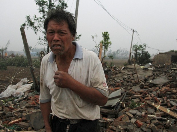 Homem lamenta destruição de casa após passagem de tornado em Yancheng, na provínce de Jiangsu, na China, na quinta-feira (23)  (Foto: China Dailyvia Reuters)