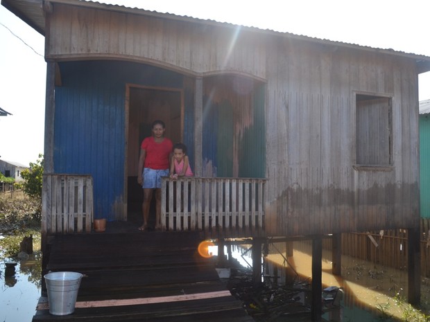 Mesmo com a casa alagada, a dona de casa Sueli Mendes Ferreira preferiu ficar em casa com a família (Foto: Vanísia Nery/G1)