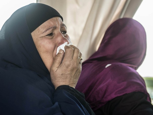 Parente de pessoa que estavam a bordo do voo MS804 da EgyptAir chora enquanto é transportada com outros familiares até local de atendimento da companhia aérea no Aeroporto Internacional do Cairo, no Egito (Foto: Khaled Desouki/AFP)