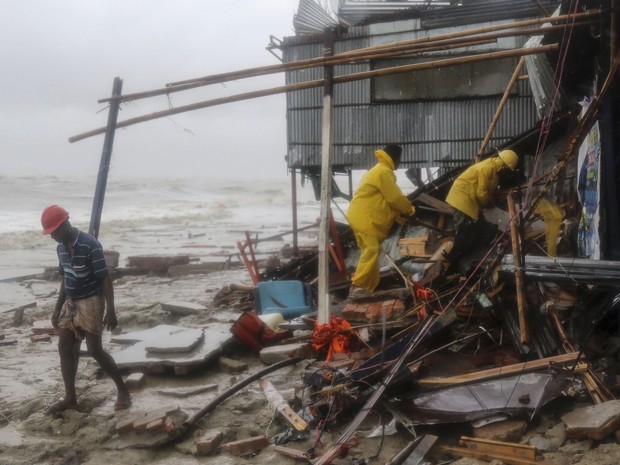 Equipe de resgate procura por sobreviventes após passagem do ciclone Roanu, neste sábado (21). (Foto: AFP)
