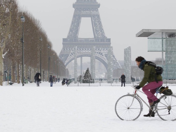 Ciclista enfreta neve acumulada próximo da Torre Eiffel (Foto: John Schults/Reuters)