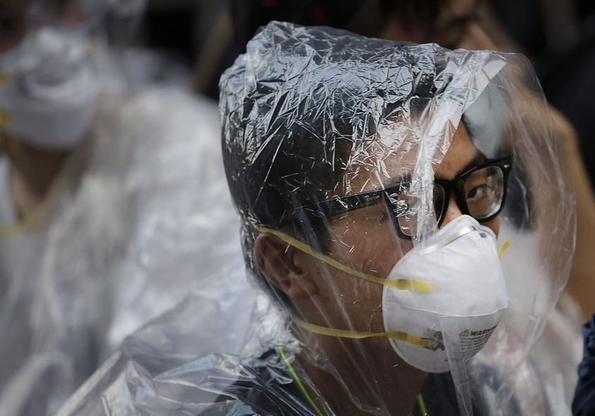 Estudante cobre o rosto para se proteger do spray de pimenta durante manifestação pró-democracia em Hong Kong, na China. Houve confronto com a polícia