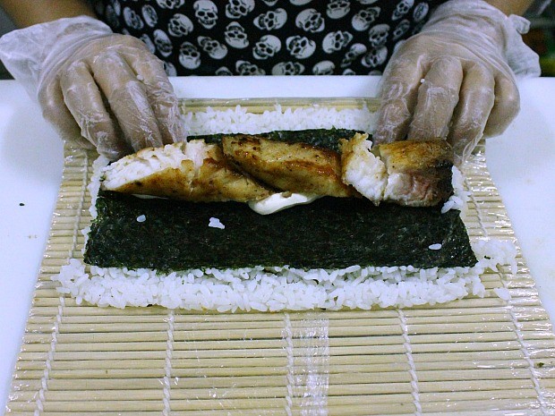 Cubra a alga com arroz e vire para incluir o cream cheese e o peixe ao centro (Foto: Leandro Tapajós/G1 AM) Cubra a alga com arroz e vire para incluir o cream cheese e o peixe ao centro (Foto: Leandro Tapajós/G1 AM)