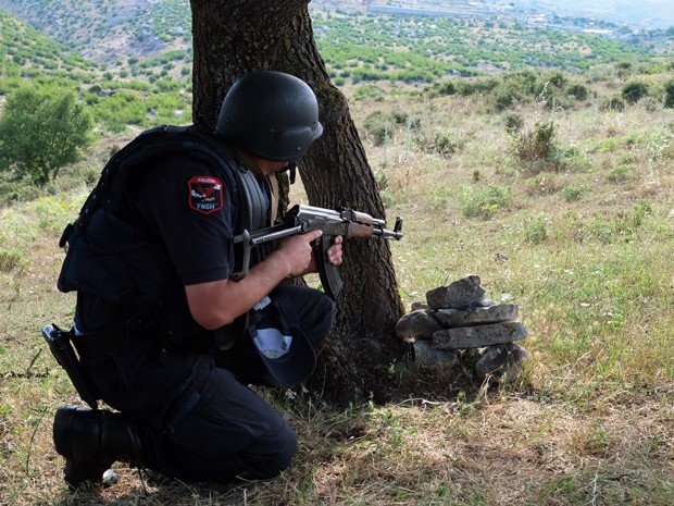 Policial atua em operação contra produtores e traficantes de maconha na vila de Lazarat, na Albânia, na quarta (24) (Foto: AFP Photo/Gent Shkullaku)