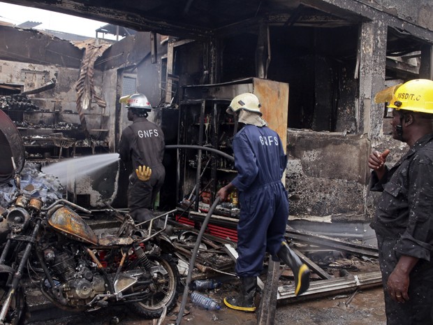 Bombeiros fazem rescaldo nas ruínas de posto de gasolina que explodiu em Acra, capital de Gana, na quinta-feira (4) (Foto: AP Photo/Christian Thompson)