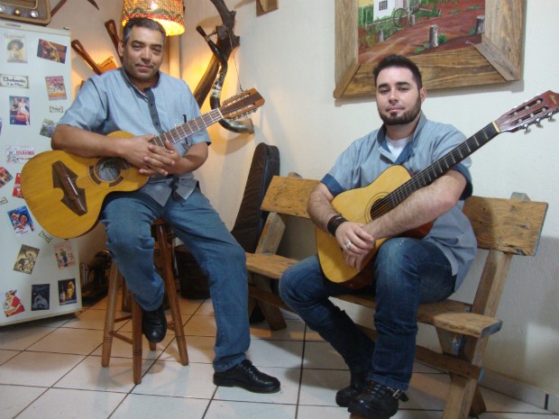 Os barbeiros João Cruz e Carlos Babugia aproveitam os intervalos para tocar viola e violão (Foto: Rodrigo Saviani/G1)