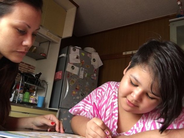 Arianne e a filha Hayenne, que ainda não pode frequentar a escola por causa do diagnóstico (Foto: BBC)