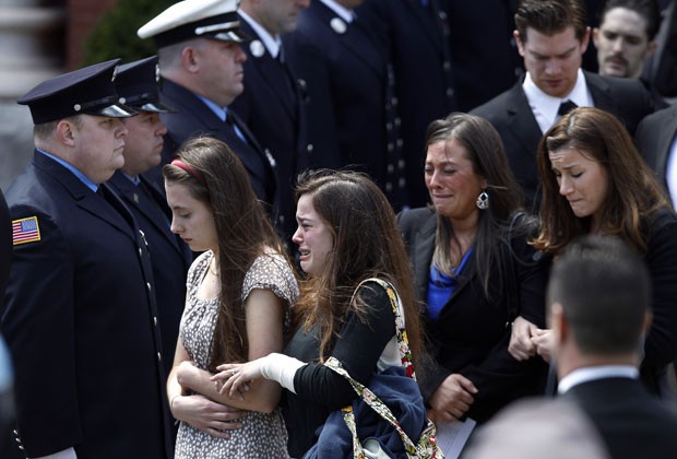 Pessoas deixam o funeral Krystle Campbell, de 29 anos, uma das vítimas das explosões de Boston, nesta segunda (22) (Foto: Elise Amendola/AP)