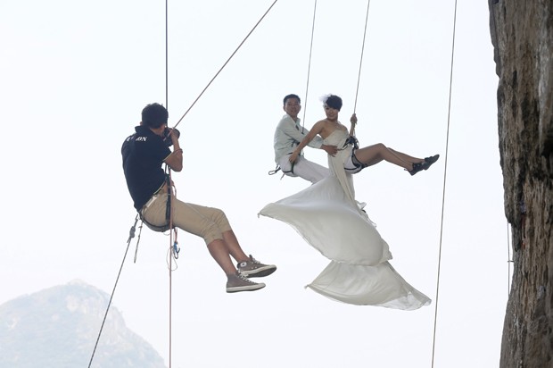 Casal posa para fotos de casamento durante escalada na China (Foto: Reuters/Stringer)