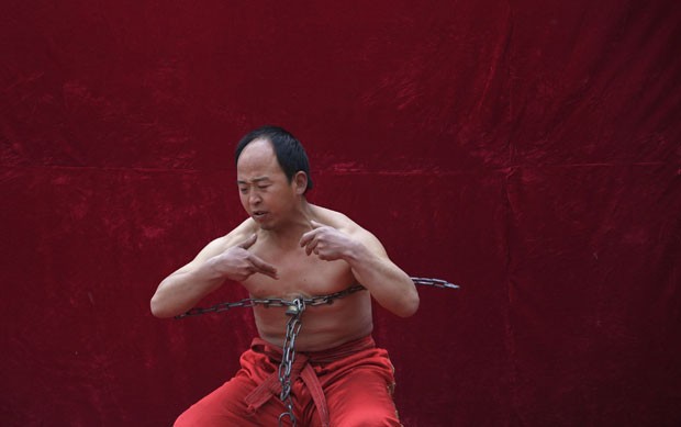 Artista chinês quebrou uma corrente usando a força de seu peito (Foto: Petar Kujundzic/Reuters)