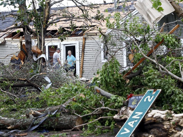 Um homem e uma mulher conversam na entrada de uma casa que foi destruída por tornado em Van, no Texas, na segunda-feira (11) (Foto: Reuters/Mike Stone)