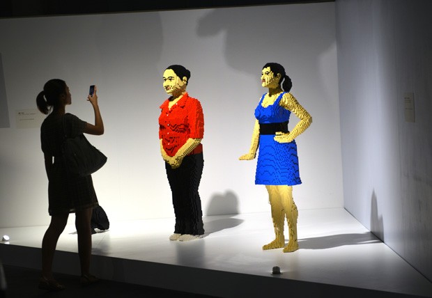 Visitante tira foto de figuras humanas feitas de Lego (Foto: Peter Parks/AFP)