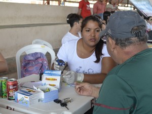 Servidor público recebendo orientações sobre o exame de glicemia (Foto: Graziela Miranda/G1)