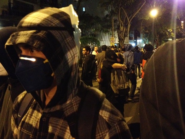 Casal se abraça em meio a manifestantes mascarados (Foto: Gabriel Barreira / G1)