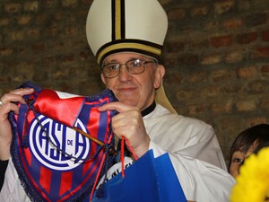 O então cardeal Jorge Mario Bergoglio posa para foto segurando uma flâmula do seu time (Foto: Club Atlético San Lorenzo de Almagro/AP)