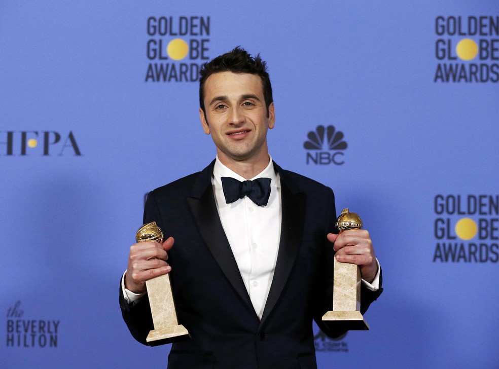 O compositor Justin Hurwitz segura os dois troféus que ganhou no Globo de Ouro 2017: melhor canção original, pela música 'City of stars', e melhor trilha sonora, ambas do filme 'La la land: Cantando estações' (Foto: Mario Anzuoni/Reuters)