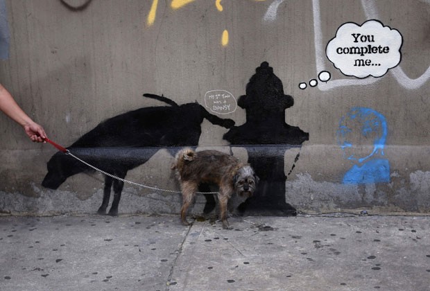 3 de outubro - Um cão imitou a arte e foi flagrado urinando em um grafite do artista Banksy em Nova York, nos EUA, que mostra um cachorro urinando em um hidrante (Foto: Mike Segar/Reuters)