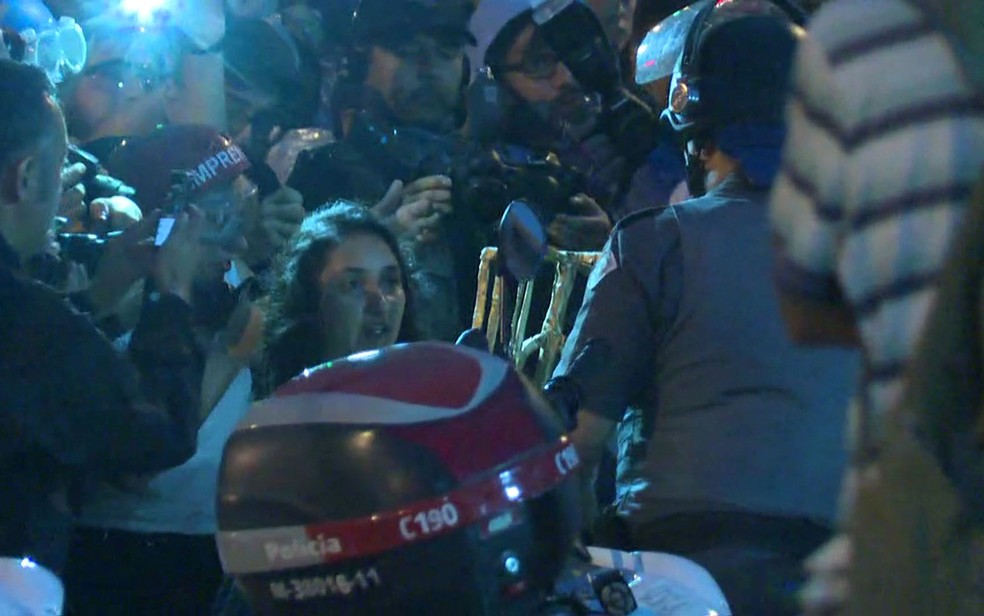 Manifestante entrega 'troféu catraca' para oficial da PM (Foto: Reprodução/TV Globo)