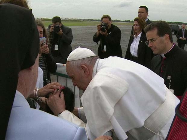 Papa Francisco beija menino em cadeira de rodas neste sábado (26) no aeroporto da Filadélfia (Foto: BBC)