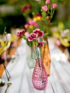 Vasos com flores miúdas é uma das dicas para enfeitar a mesa em um almoço no jardim