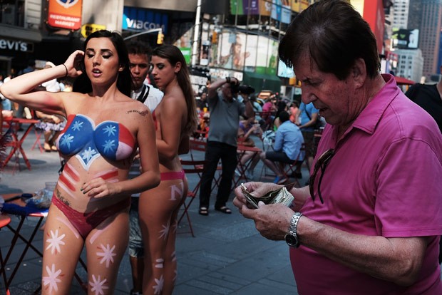 Em troca de dinheiro, mulheres seminuas posam com pintura corporal. (Foto: Spencer Platt/Getty Images/AFP) Em troca de dinheiro, mulheres seminuas posam com pintura corporal. (Foto: Spencer Platt/Getty Images/AFP)